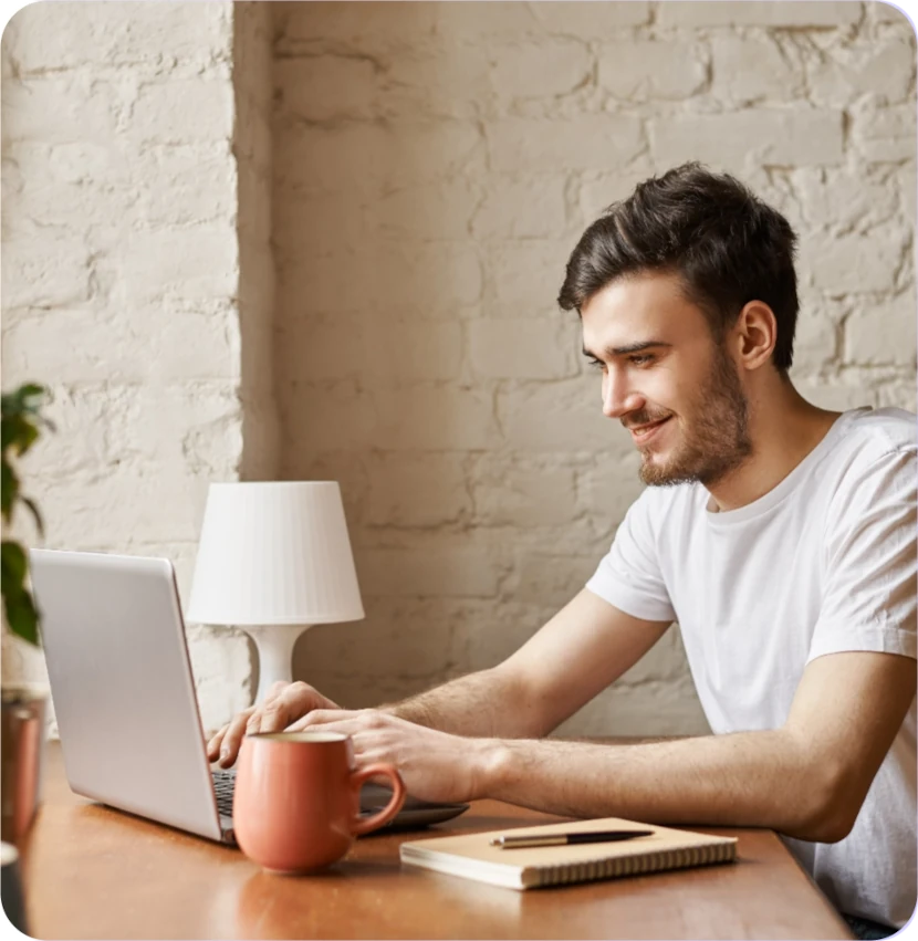 hombre frente a una laptop sonriendo