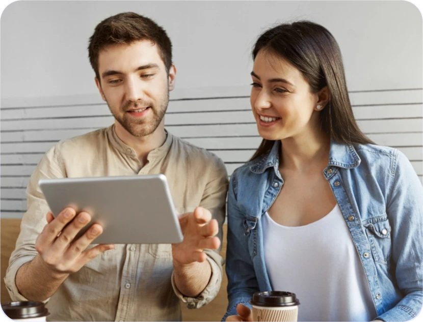 un hombre y una mujer viendo una tablet